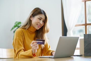 Woman shopping on laptop holding credit card for Internet online e-commerce shopping spending money Online shopping Mobile phone laptop technology concept