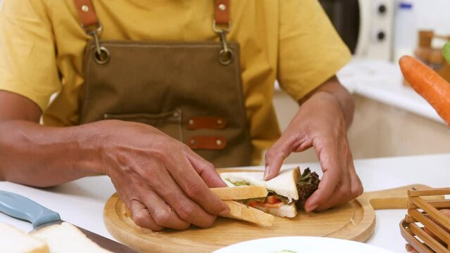 unrecognizable chef's hands preparing sandwiches for customers on wooden board in kitchen restaurant, closeup worker working in cuisine, small business owner lifestyle cooking on own service customers