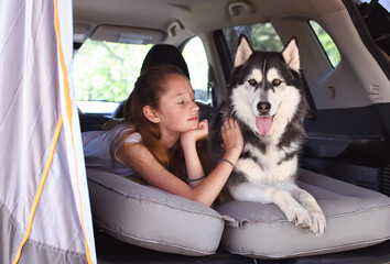 child with their pet dog car camping