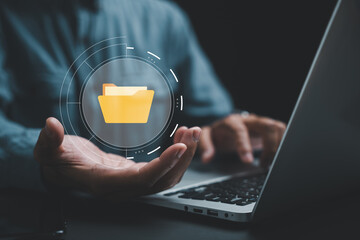 Hand holding a folder icon on a virtual screen, symbolizing a Document Management System (DMS). Streamline information management and archive efficiently with ERP. Corporate technology in practice.