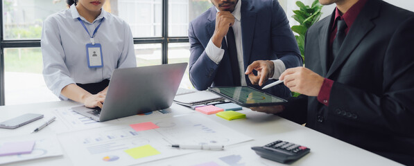 Businessman and team analyzing financial statement Finance task. with smart phone and laptop and...