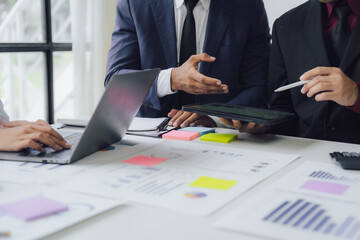 Businessman and team analyzing financial statement Finance task. with smart phone and laptop and...