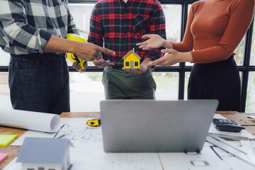 Engineer and contractor planning projects together at desk with blueprints.
