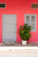 Bright pink asiatic accommodation. Facade of small local traditional house.