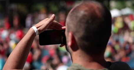 A man takes a view from the back on a smartphone camera, a close-up. Video for social networks, stadium arena - Powered by Adobe