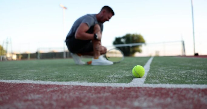 Pain in the person leg in an open tennis court, slowmotion. Injuries and illness in sports, active leisure
