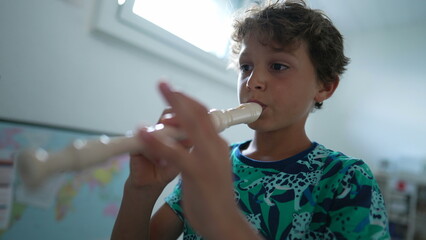 Young musician playing flute rehearsing with musical instrument - obrazy, fototapety, plakaty
