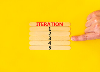 Time to iteration 3 symbol. Concept word Iteration 1 2 3 4 5 on wooden sticks. Businessman hand. Beautiful yellow table yellow background. Business planning and time to iteration 3 concept. Copy space