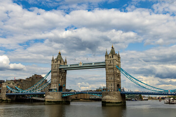Fototapeta na wymiar A famous bridge in London with two towers and blue spans underneath a cloudy sky