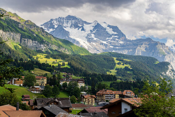 Fototapeta na wymiar A view of the Swiss Alps and the village of Lauterbrunnen in the Berner Oberland area of Switzerland, with mountains in the background, a valley and chalets in the foreground