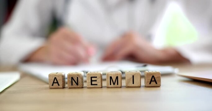 Anemia inscription on wooden cubes on the table, close-up. Visit to a hematologist, prevention and treatment