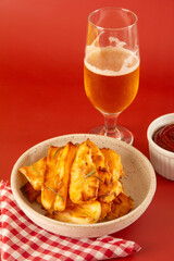 Top view Delicious Fried Cassava in Handcrafted White Ceramic Bowl on Red Studio Background