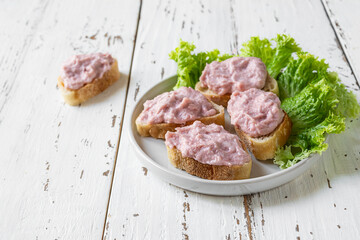 Crostini with tarama or taramasalata canape on the white wooden table