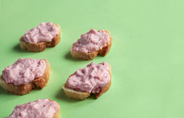 Crostini with tarama or taramasalata canape isolated on the green background