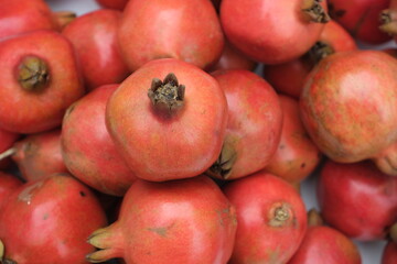 Fototapeta na wymiar Pomegranates on the counter. Red ripe fruits.Background from whole pomegranates.