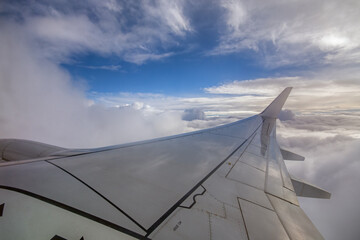 A view from aircraft wing during climb when passing through the clouds during an early morning hour 