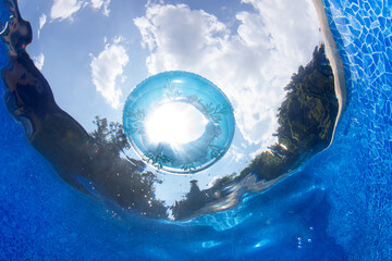 View from bottom of the pool to the sky with white clouds.
