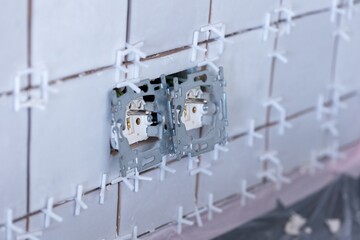 A portrait of two connected electric wall sockets without their protective plastic caps in a newly...
