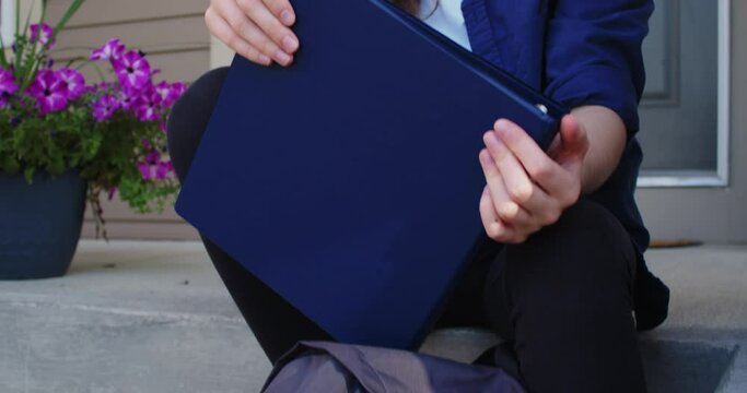 Sad Student Sitting on Steps Outside of a Suburban House