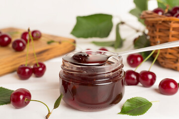 Jar with tasty homemade cherry jam on wooden table