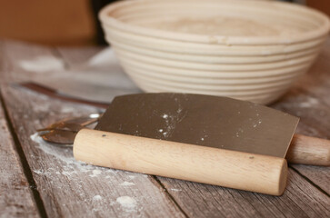Sourdough bread baking set up with cutting tool in focus and the rest in the background