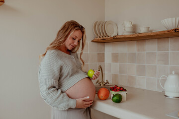 Pregnant woman in the kitchen with fruits