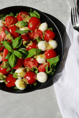 upper view of a delicious Italian capers salad with tomatoes, mozzarella and basil