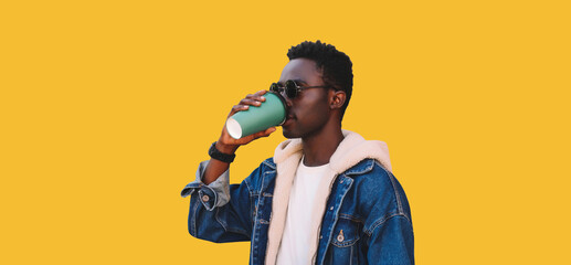 Portrait of stylish young african man drinking coffee isolated on yellow background
