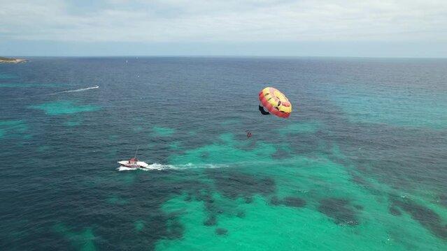 Aerial view of tourists enjoying parasailing in Sa Coma beach in Mallorca, Spain on a summer day