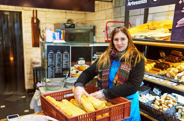 portrait young adult caucasian woman baker working replenishing groceries in a small business in Buenos Aires