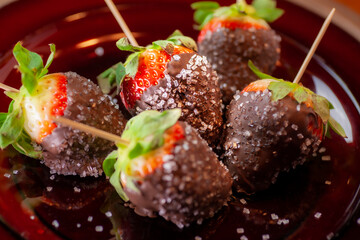 Chocolate dipped strawberries sprinkled with sugar crystals.