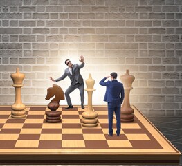 Businessman in large chess board in strategy concept