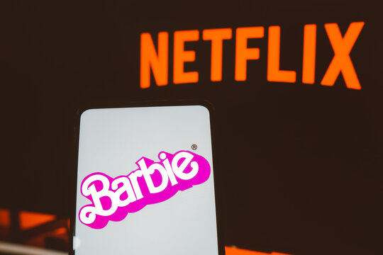 July 21, 2023, Brazil. In this photo illustration, the Barbie the movie logo seen displayed on a smartphone. In the background, the Netflix streaming logo.