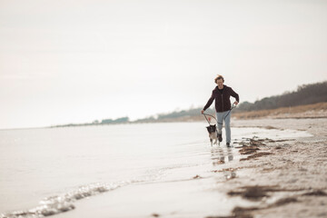 Mature man jogging on the beach with his dog