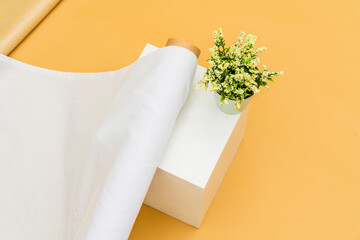 A minimalistic set up beautifully showcases the mockup use of a white fabric roll image, creating a tranquil and stylish environment
