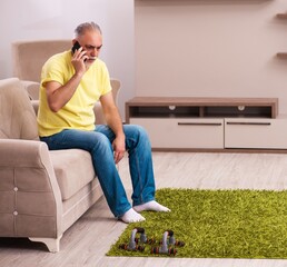 Aged man doing sport exercises at home