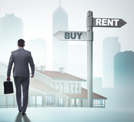 Businessman at crossroads betweem buying and renting