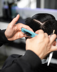 combing hair to cut in barbershop