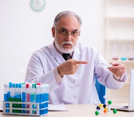 Old male chemist working in the lab