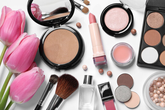 Flat lay composition with different makeup products and beautiful tulips on white background