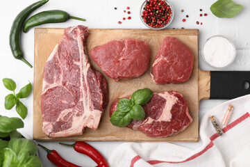 Flat lay composition with cut fresh beef meat and spices on white table
