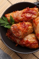 Delicious stuffed cabbage rolls cooked with tomato sauce on table, top view