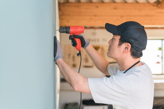 電動ドライバー・電動ドリルを使う日本人男性（DIY）
