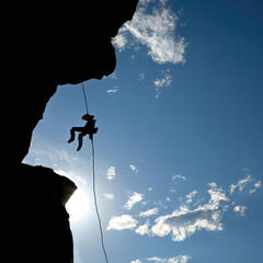 Silhouette of a rock climber on rappel - obrazy, fototapety, plakaty