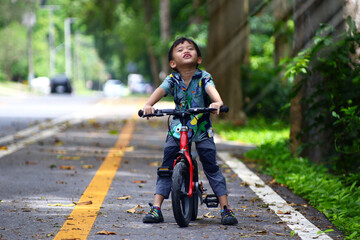 Boy riding bike on dirt path in the park