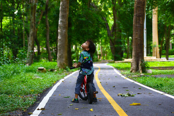 Boy riding bike on dirt path in the park