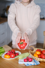 Age woman holding a large ripe tomato in her hands