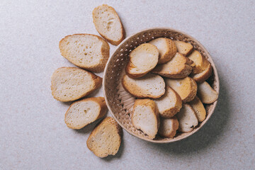Delicious croutons. Pieces of roasted white bread. Sliced bread on a table, top view. Croutons in the wicker basket.