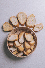 Delicious croutons. Pieces of roasted white bread. Sliced bread on a table, top view. Croutons in the wicker basket.