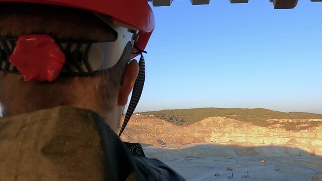 Male engineer worker in gold digging quarry checking the open pit mine from hight, slow motion